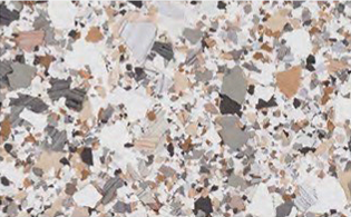 A close-up of a terrazzo floor surface with scattered chips in white, beige, gray, and brown tones.
