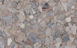 Close-up of a surface covered with irregularly shaped, small, gray and beige stone or tile fragments.